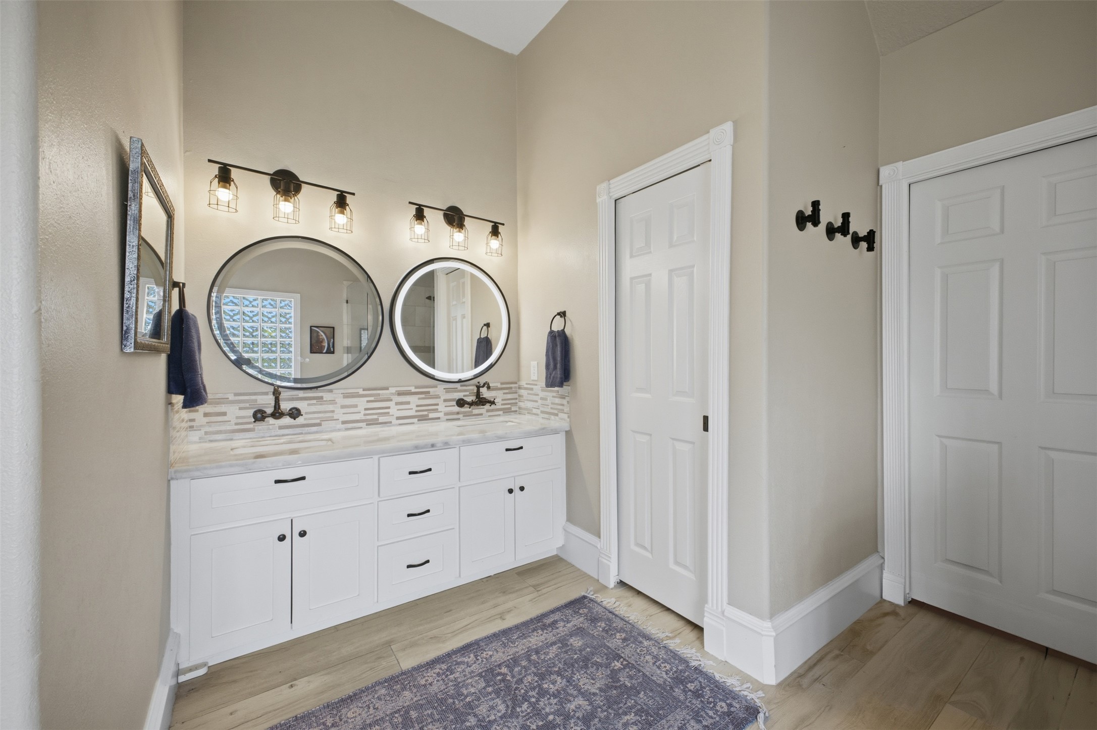 12710 Aries Loop Willis, TX 77318 - Photo 20 of 40 Bathroom featuring a dual vanity with white cabinetry, round mirrors, and overhead lighting