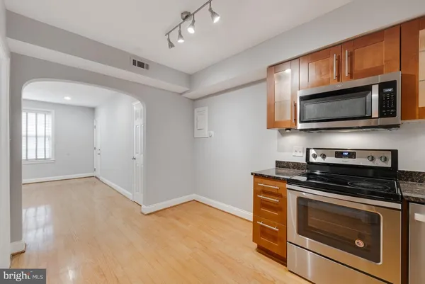 a kitchen with granite countertop wooden cabinets stainless steel appliances and a counter space