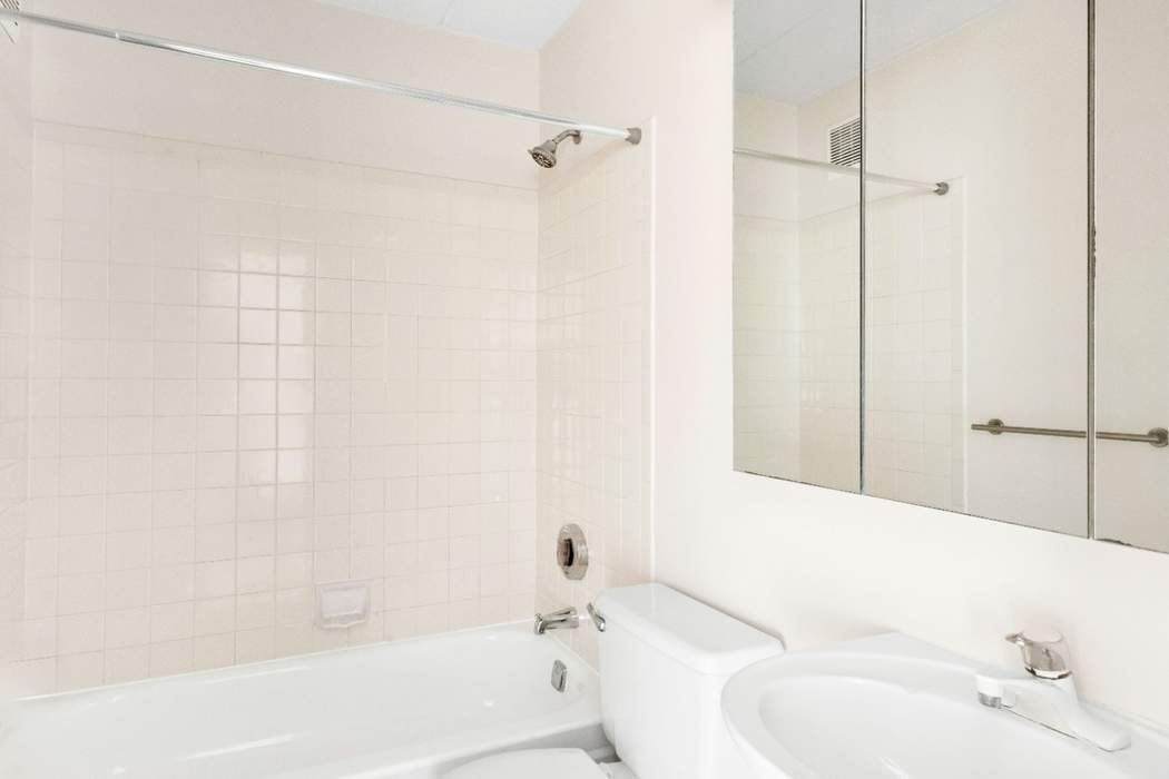 23-22 30th Road, Unit 10H Queens, NY 11102 - Photo 8 of 16 a bathroom with a bathtub and shower