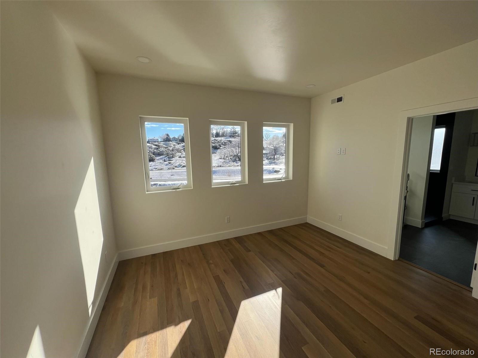 2398 Ridge Cir Drive, Unit A Grand Junction, CO 81507 - Photo 13 of 30 a view of an empty room with wooden floor and a window
