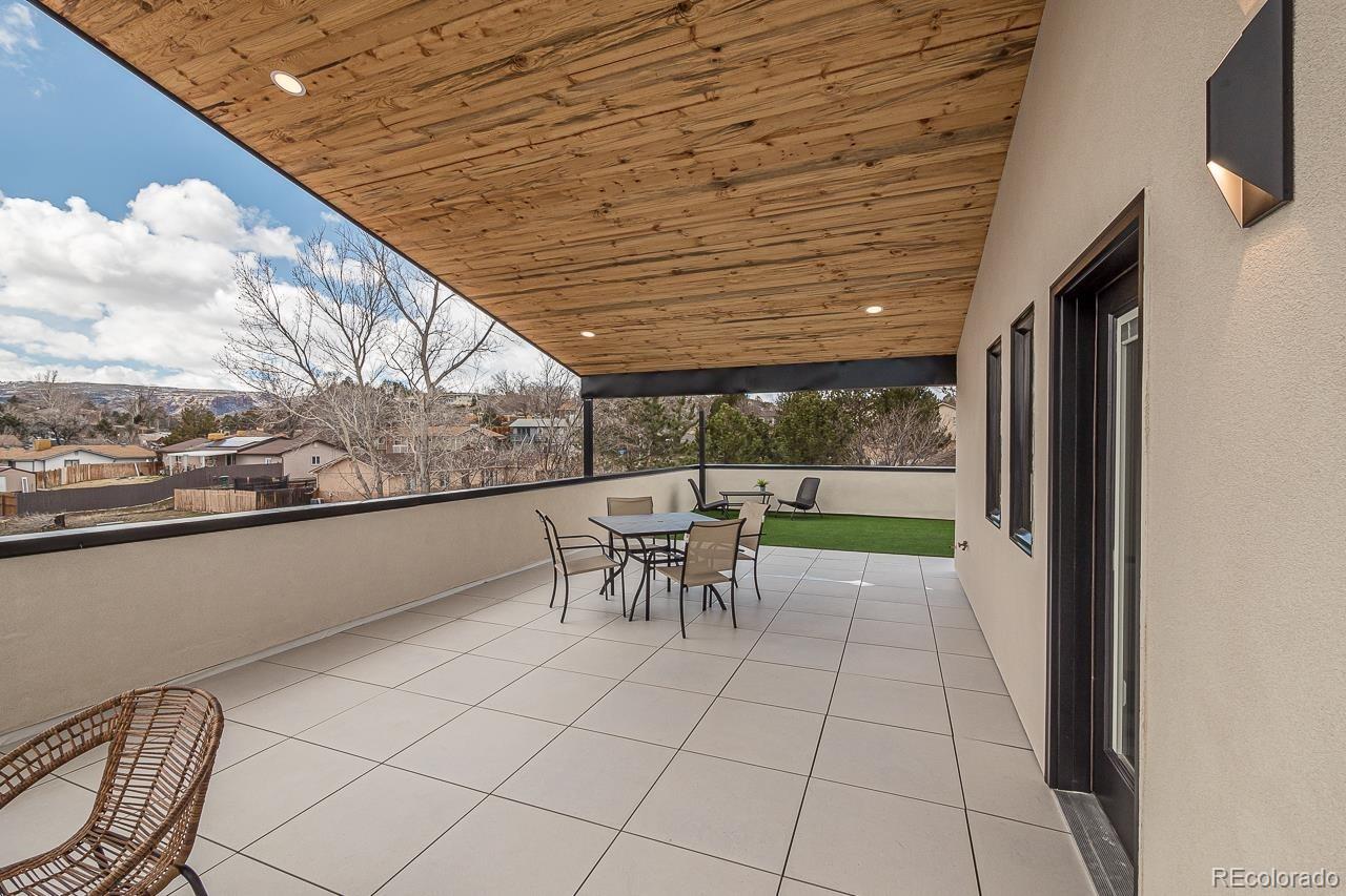 2398 Ridge Cir Drive, Unit A Grand Junction, CO 81507 - Photo 20 of 30 a view of a patio with table and chairs with wooden floor and fence