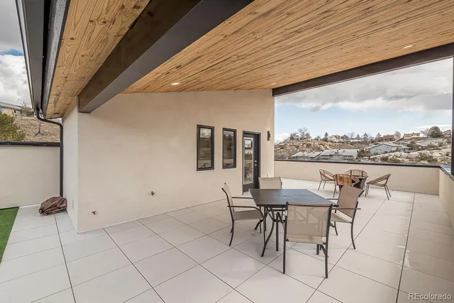 a roof deck with table and chairs