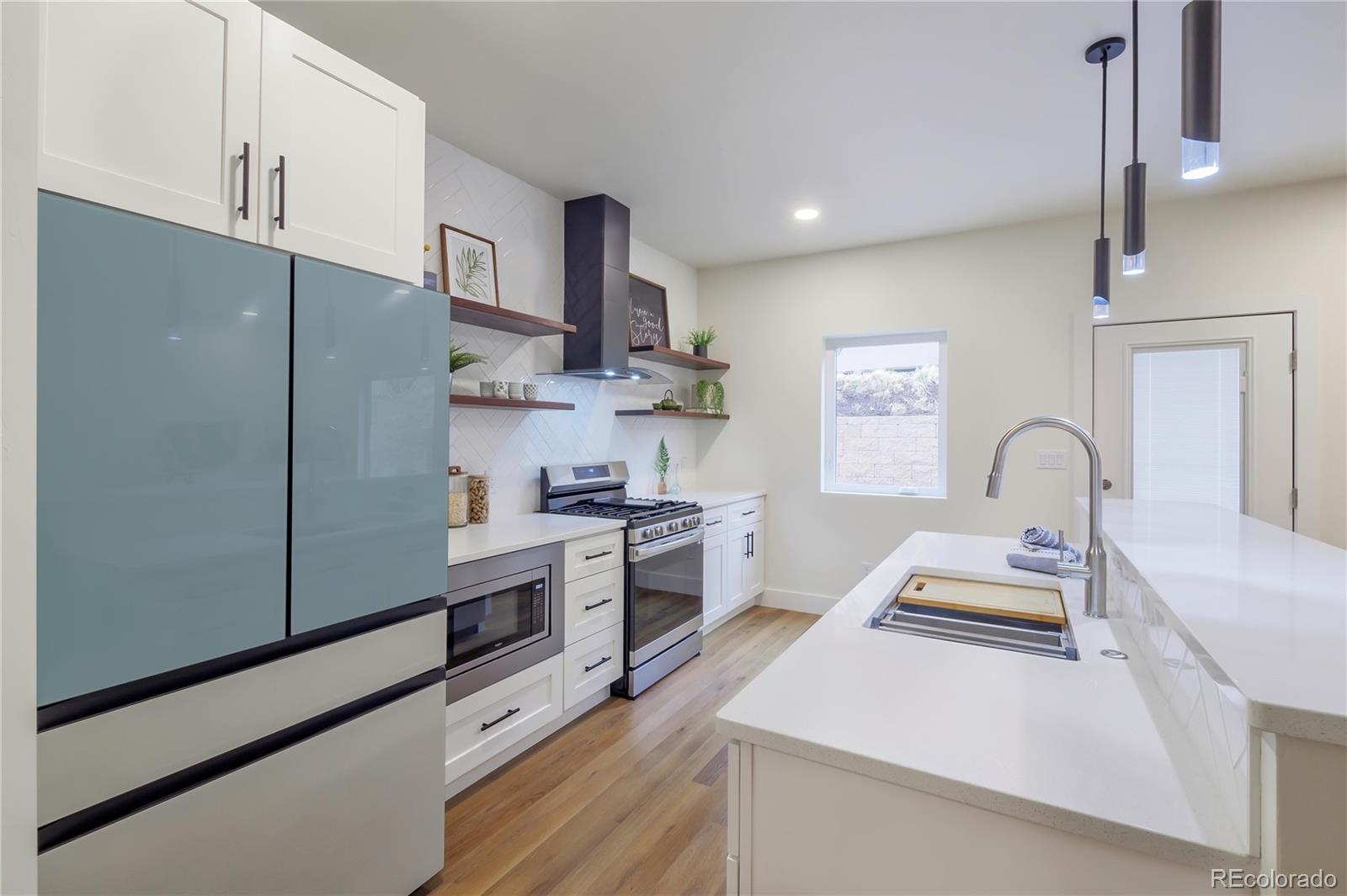 2398 Ridge Cir Drive, Unit A Grand Junction, CO 81507 - Photo 5 of 30 a kitchen with stainless steel appliances a stove refrigerator sink and cabinets
