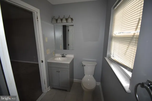 a bathroom with a sink and mirror with toilet