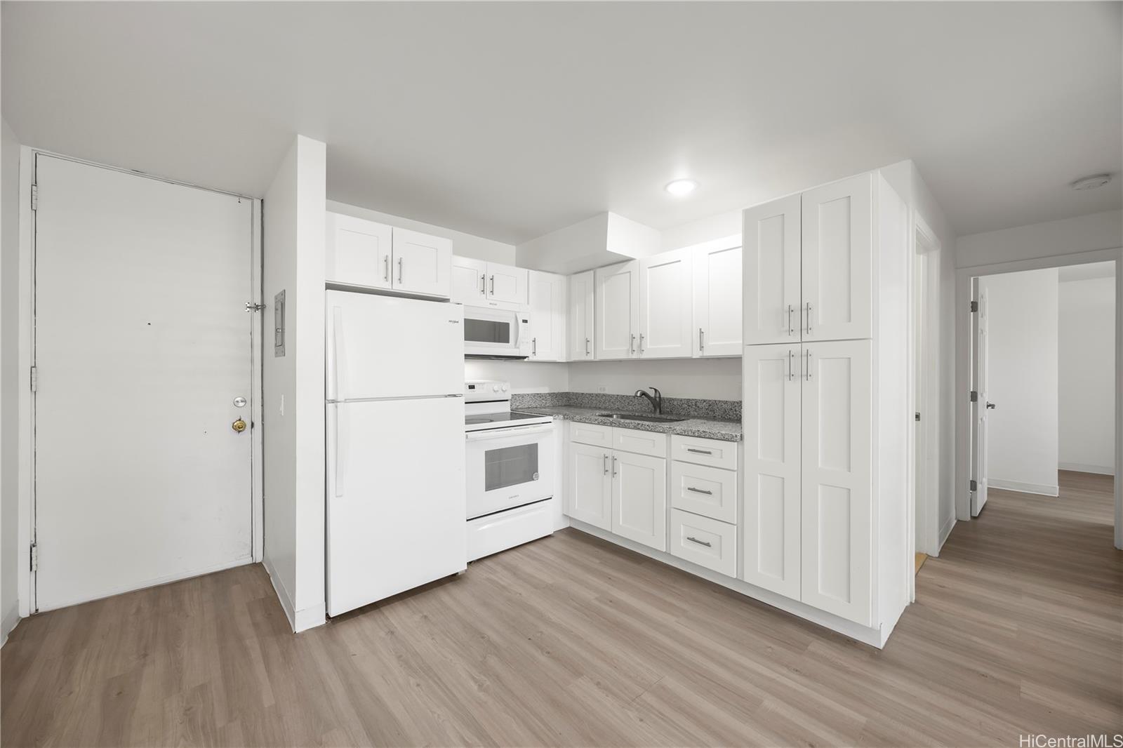 412 Launiu Street Honolulu, HI 96815 - Photo 6 of 20 a kitchen with white cabinets white stainless steel appliances and wooden floors