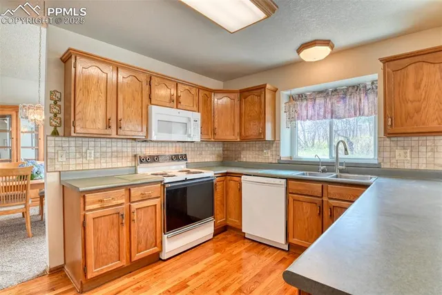 a kitchen with stainless steel appliances granite countertop wooden cabinets a sink and dishwasher a oven with wooden cabinets