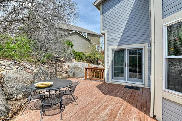 a view of a chair and table in backyard of the house