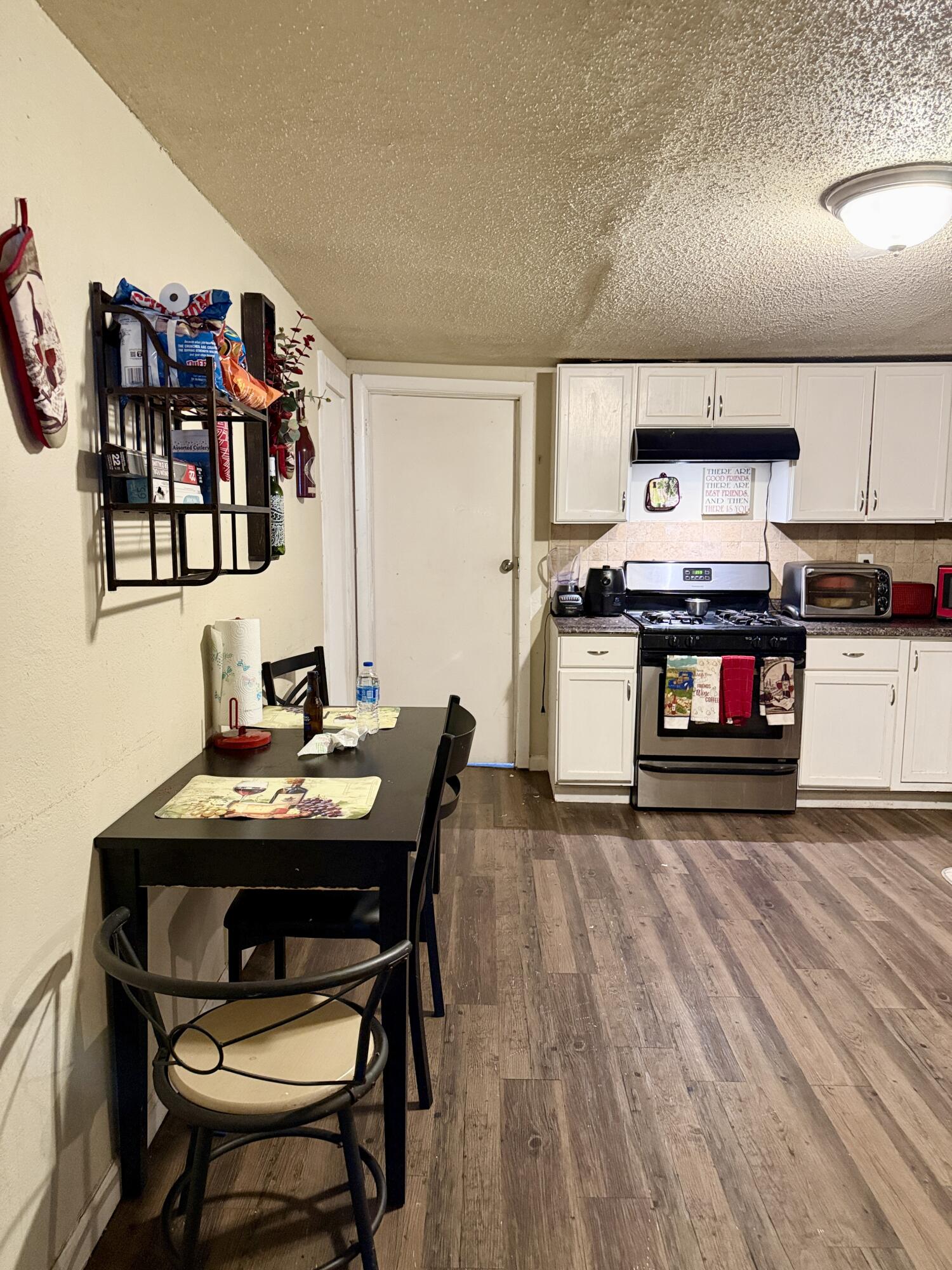 3708 Elgin Avenue Lubbock, TX 79413 - Photo 8 of 23 a kitchen with stainless steel appliances a stove a table and chairs