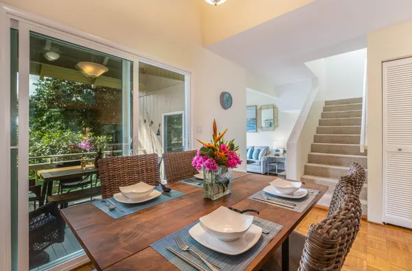 a view of a dining room with furniture a potted plant and wooden floor