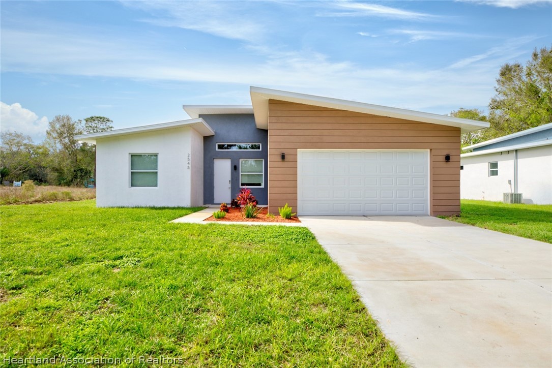 2545 Odessa Road Avon Park, FL 33825 - Photo 1 of 24 a front view of house with yard and garage