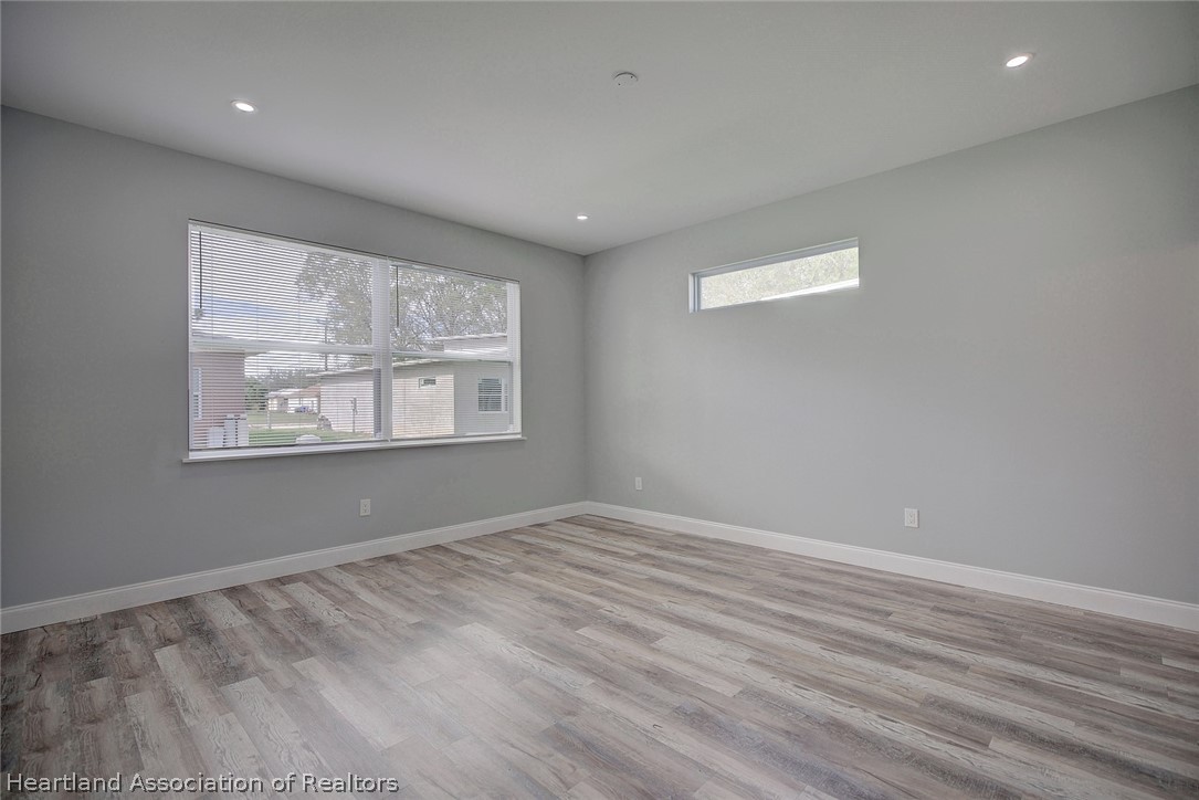 2545 Odessa Road Avon Park, FL 33825 - Photo 11 of 24 a view of an empty room with wooden floor and a window