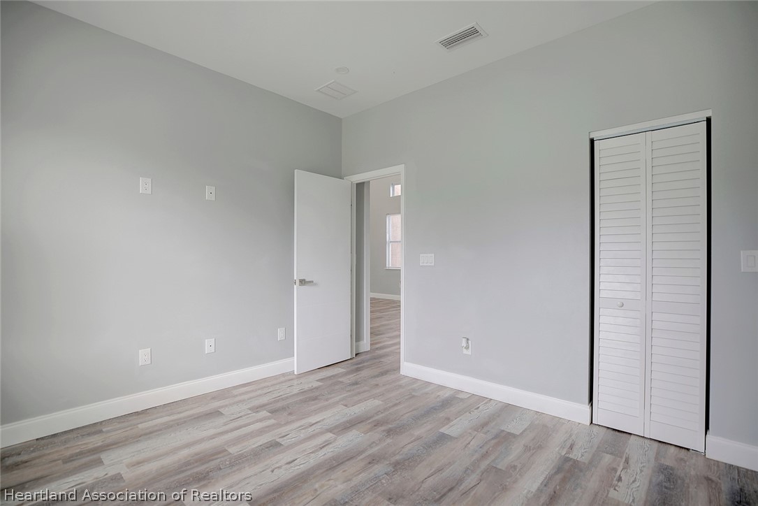 2545 Odessa Road Avon Park, FL 33825 - Photo 17 of 24 a view of an empty room with wooden floor and closet