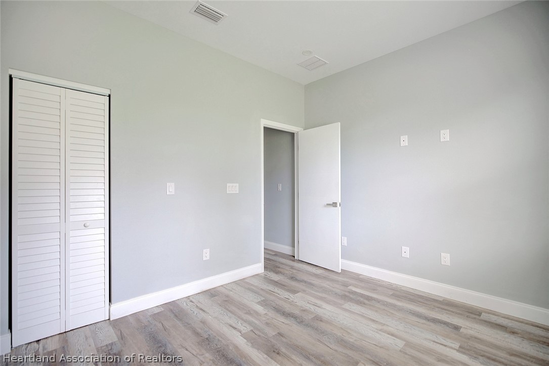 2545 Odessa Road Avon Park, FL 33825 - Photo 20 of 24 a view of an empty room with wooden floor and closet