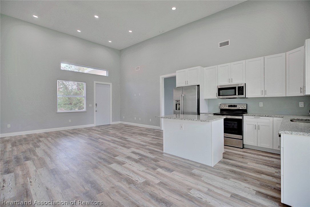 2545 Odessa Road Avon Park, FL 33825 - Photo 6 of 24 a kitchen with granite countertop white cabinets and stainless steel appliances