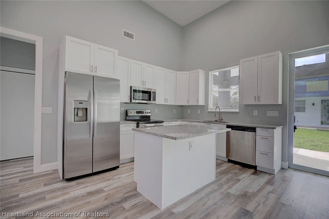 2545 Odessa Road Avon Park, FL 33825 - Photo 7 of 24 a kitchen with stainless steel appliances granite countertop a refrigerator a sink and a stove