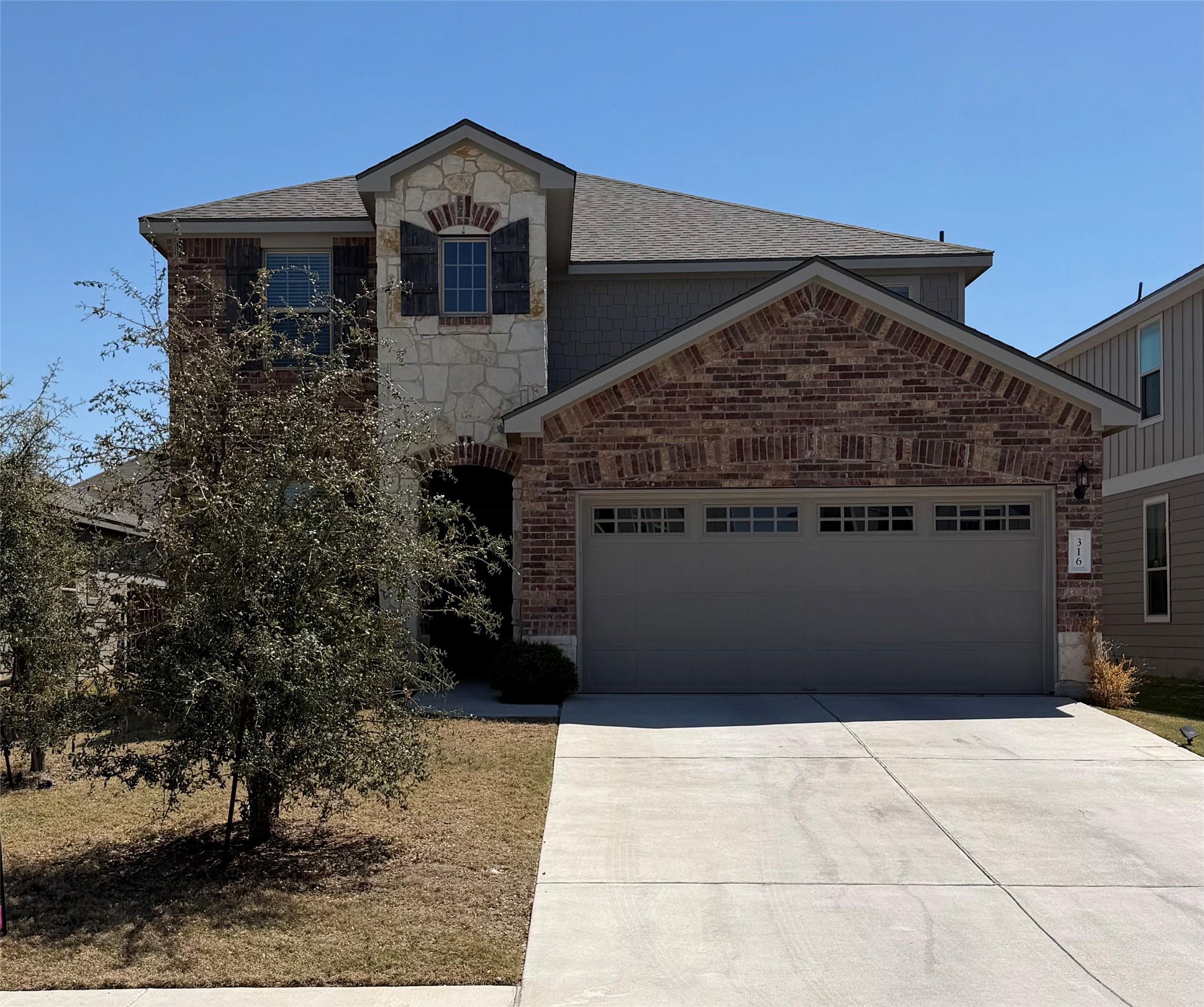 316 Harper Lane Georgetown, TX 78626 - Photo 1 of 21 View of front of house featuring an attached garage, concrete driveway, stone siding, brick siding, and roof with shingles