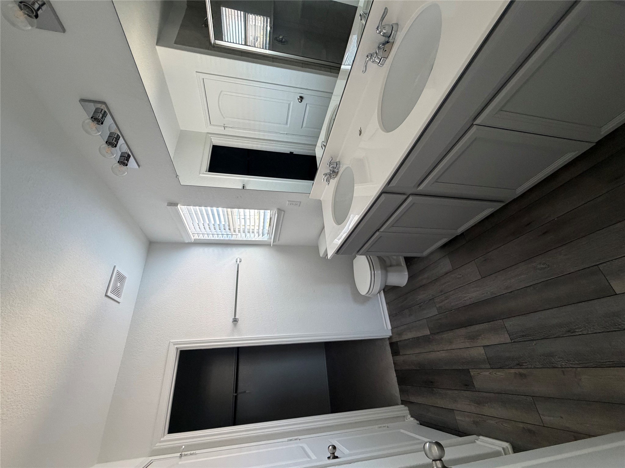 316 Harper Lane Georgetown, TX 78626 - Photo 9 of 21 Full bathroom with double vanity, dark wood finished floors, a walk in closet, walk in shower, and a textured ceiling