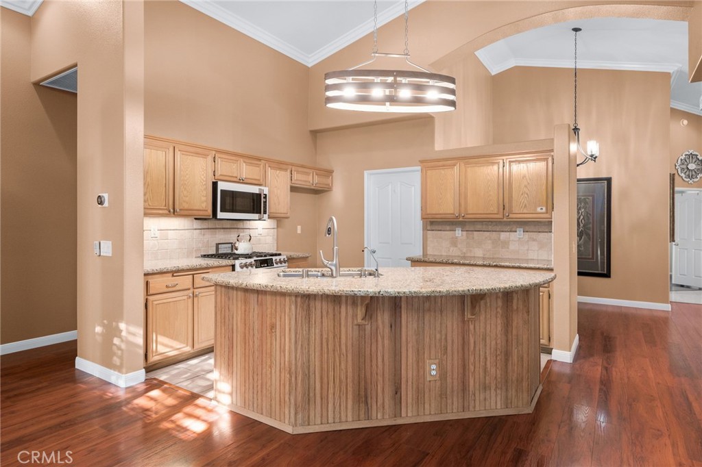 9403 Old Post Drive Rancho Cucamonga, CA 91730 - Photo 13 of 38 a kitchen with stainless steel appliances granite countertop a sink a stove a refrigerator cabinets and a wooden floor