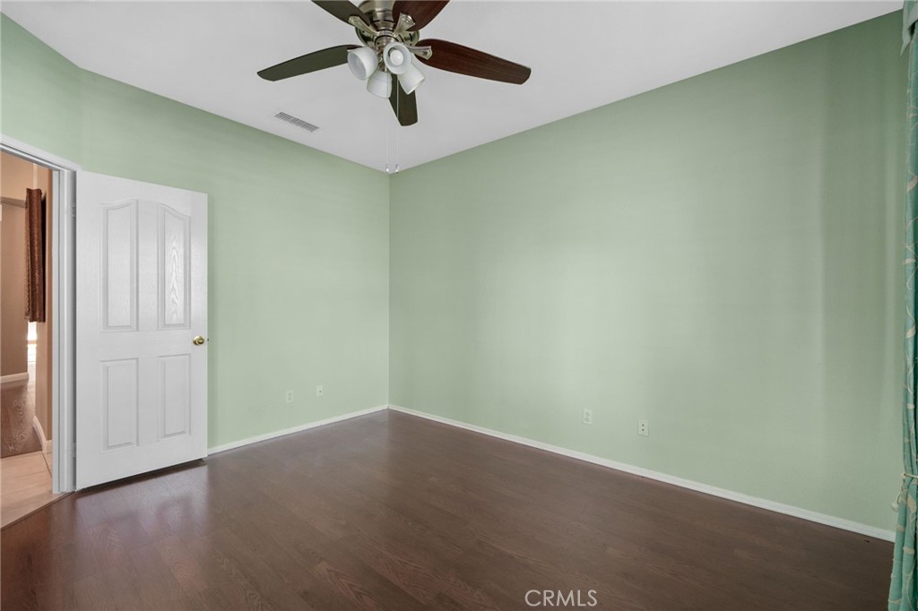 9403 Old Post Drive Rancho Cucamonga, CA 91730 - Photo 19 of 38 an empty room with a ceiling fan and wooden floor