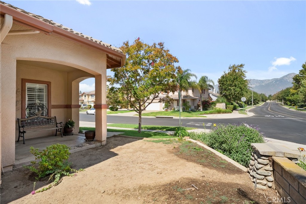 9403 Old Post Drive Rancho Cucamonga, CA 91730 - Photo 4 of 38 a front view of a house with a yard and potted plants
