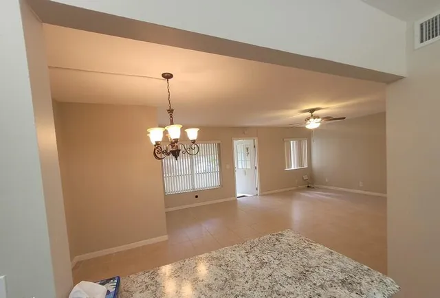 a view of a room with a ceiling fan and a window