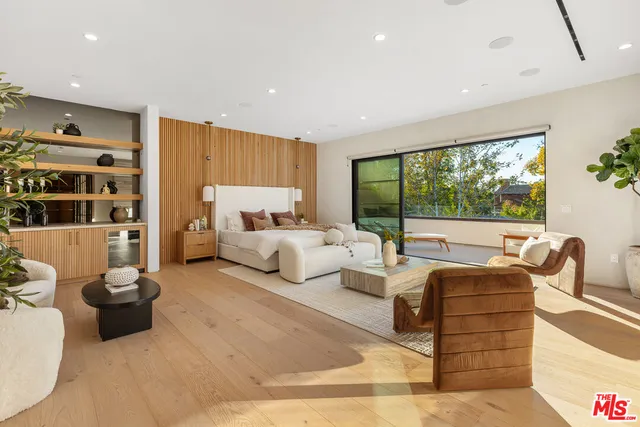 a bedroom with furniture and a large window