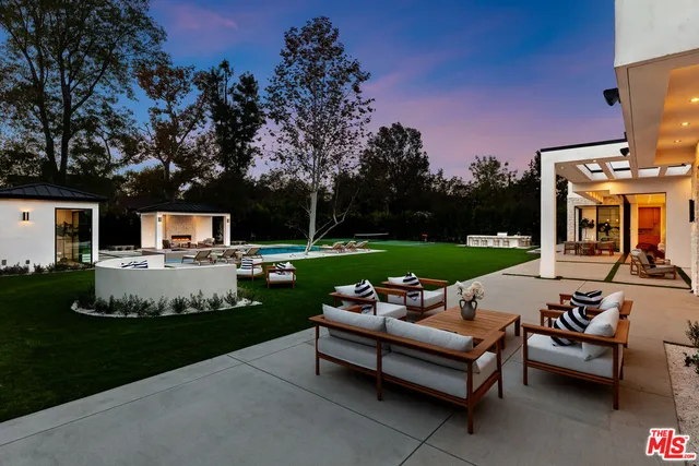 a view of a patio with couches table and chairs with garden and plants