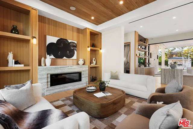 a living room with furniture a fireplace and a large window