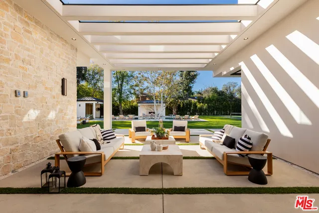 a living room with patio furniture and a large window