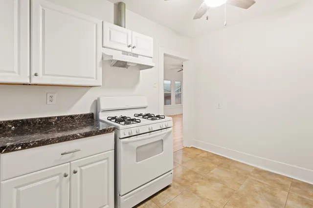 a kitchen with white cabinets and white appliances