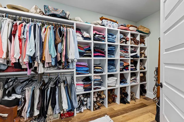 a view of walk in closet with clothes and shoes
