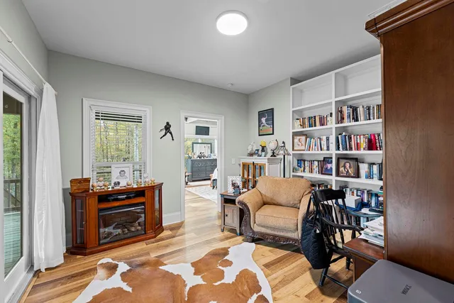 a living room with furniture a bookshelf and a window