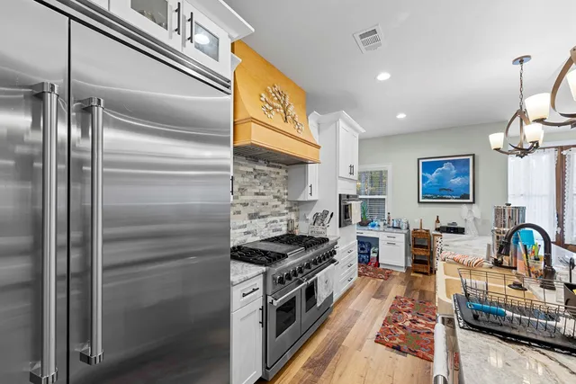 a kitchen with stainless steel appliances a stove a sink and a refrigerator