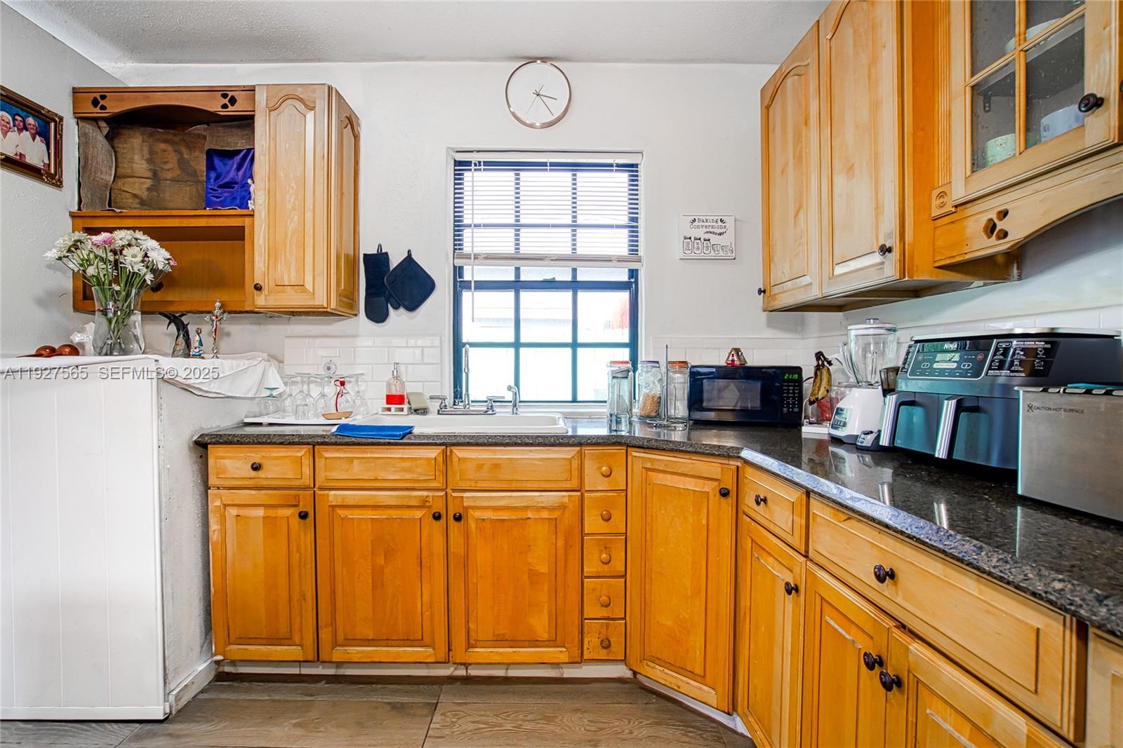 2516 Cleveland Street Hollywood, FL 33020 - Photo 13 of 42 a kitchen with stainless steel appliances granite countertop a sink and cabinets with wooden floor