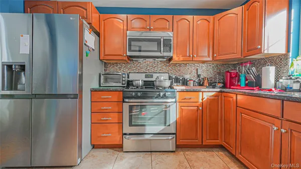 a kitchen with stainless steel appliances granite countertop a refrigerator and a stove top oven