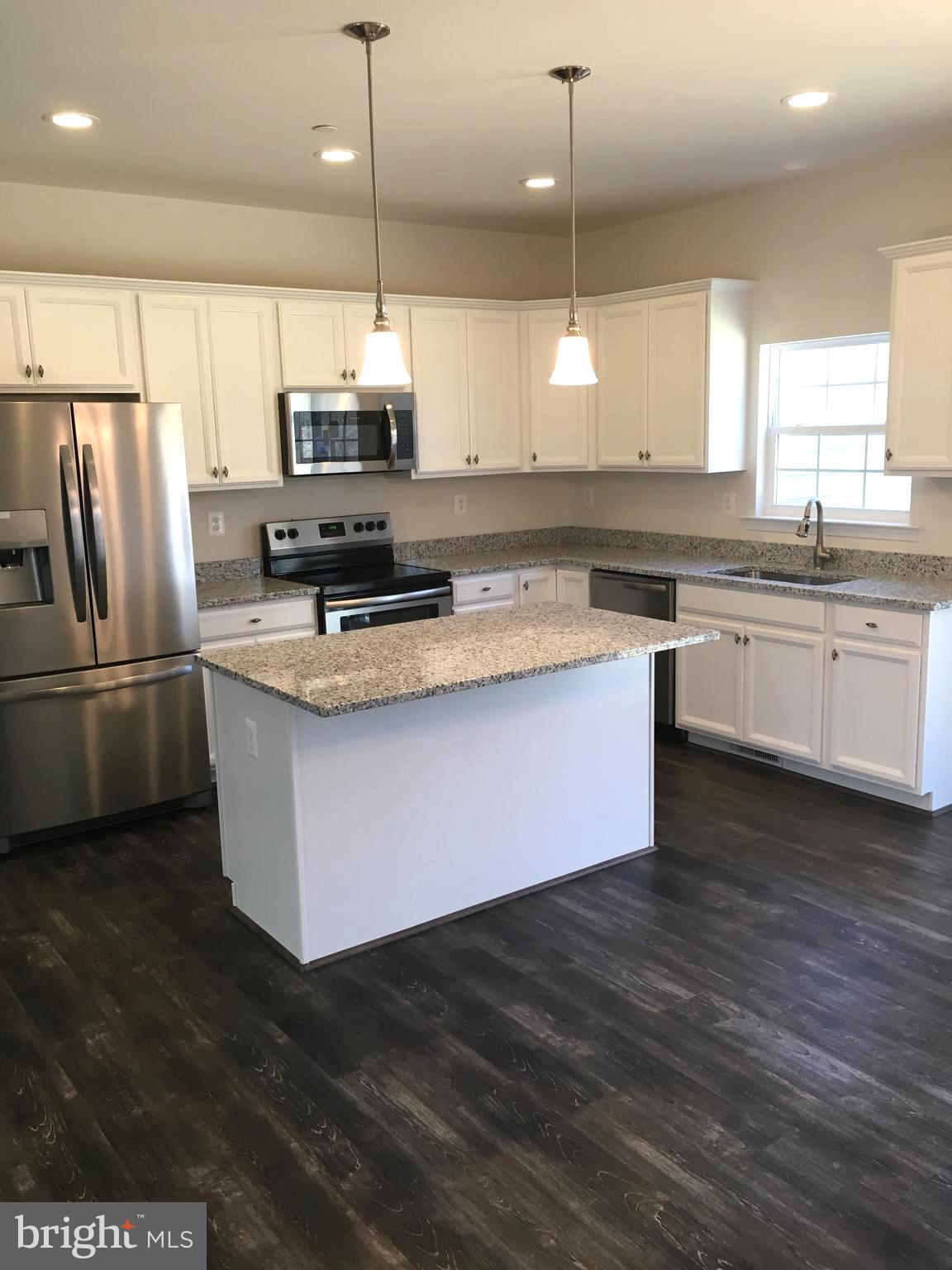 57 Chapel View Lusby, MD 20657 - Photo 4 of 5 a kitchen with kitchen island granite countertop a sink a counter space appliances and cabinets