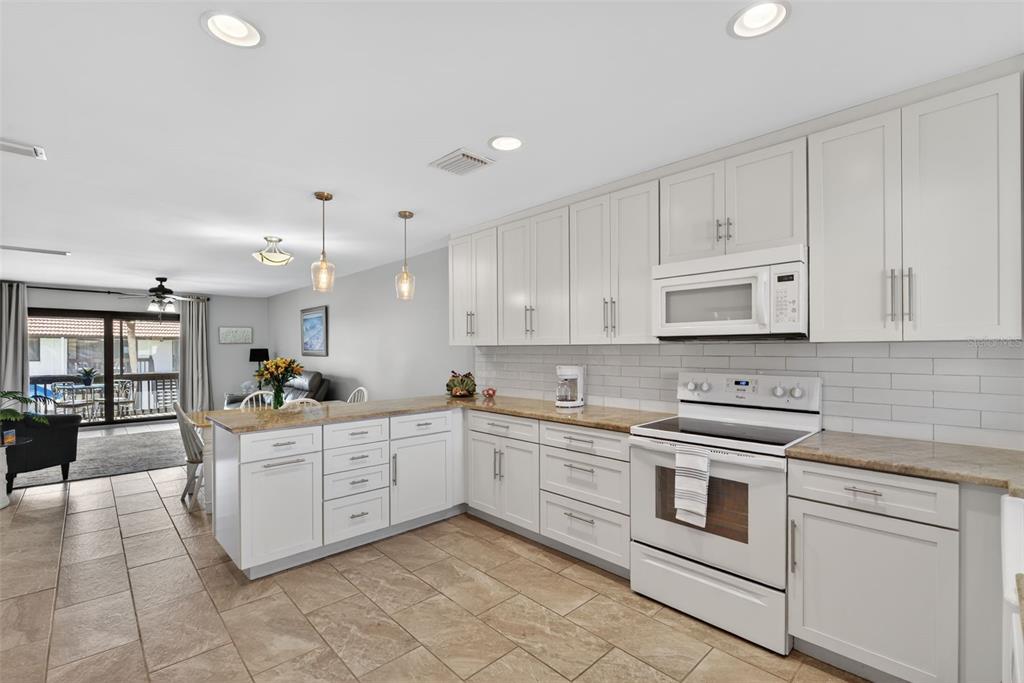 1632 Stickney Point Road, Unit 201 Sarasota, FL 34231 - Photo 11 of 43 a kitchen with cabinets and white appliances