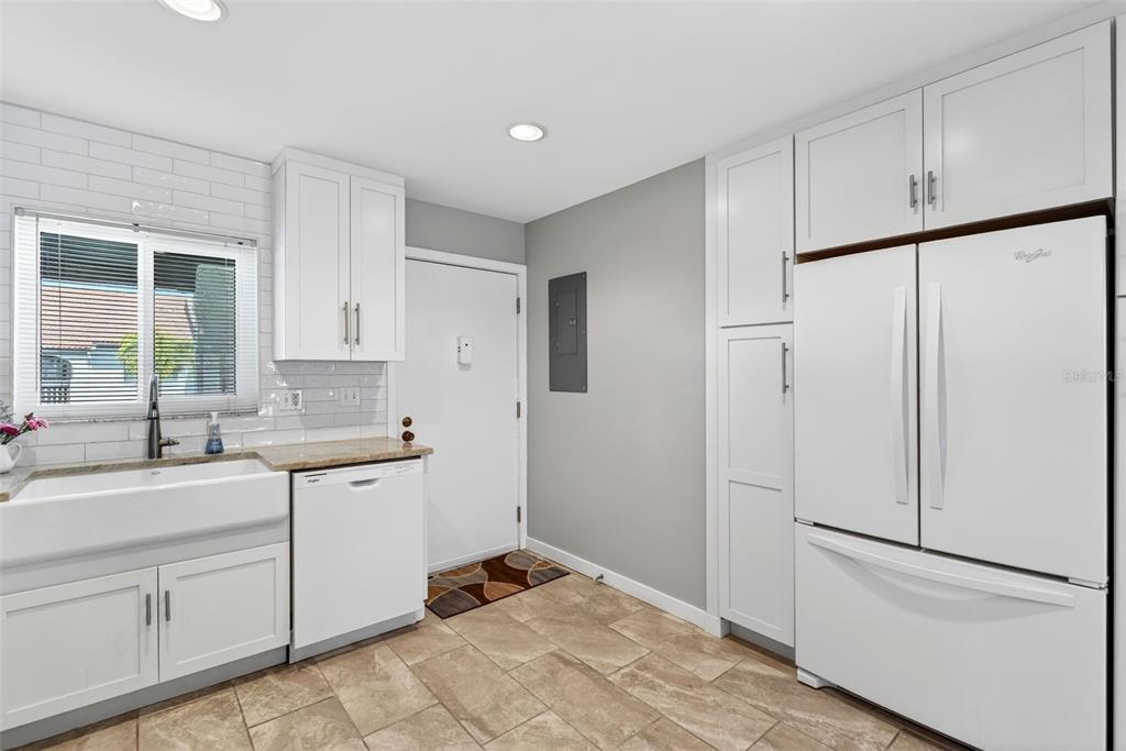 1632 Stickney Point Road, Unit 201 Sarasota, FL 34231 - Photo 12 of 43 a kitchen with white cabinets and white appliances