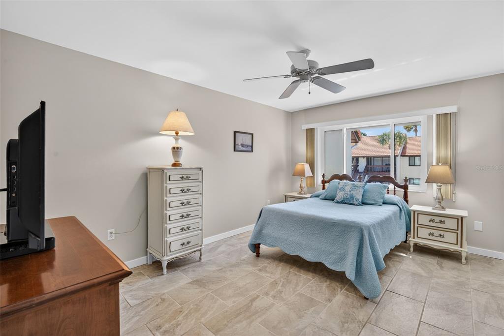 1632 Stickney Point Road, Unit 201 Sarasota, FL 34231 - Photo 15 of 43 a bedroom with a bed and a flat tv screen on dresser