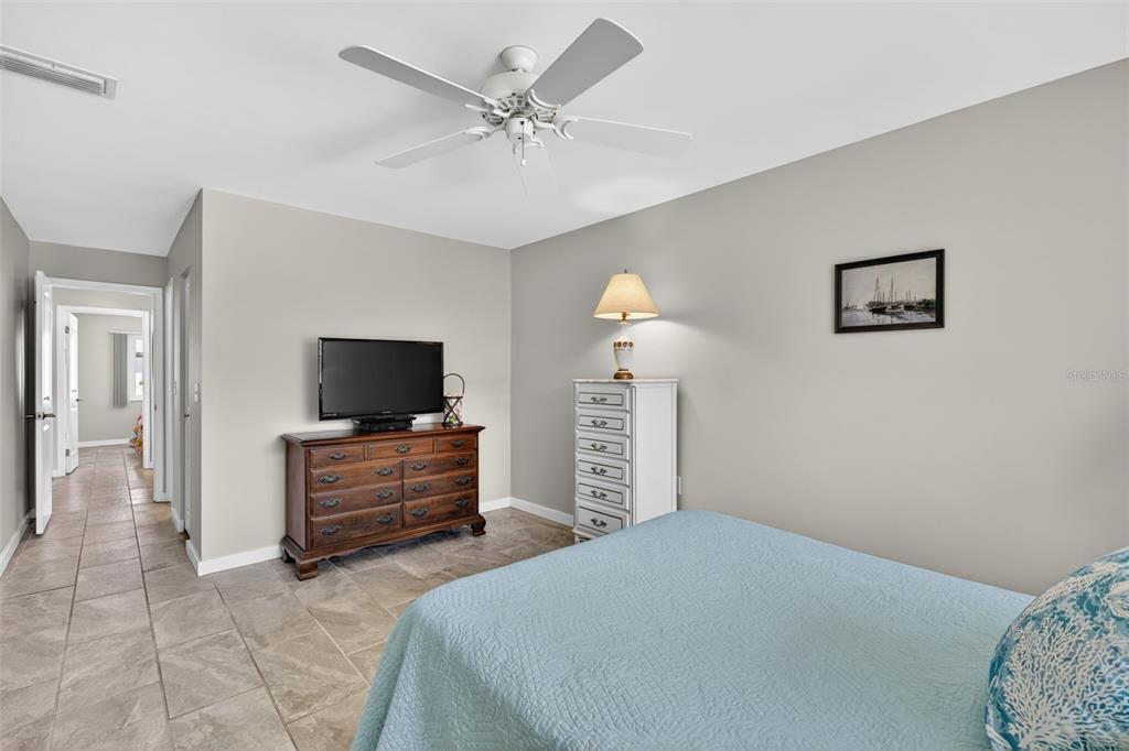 1632 Stickney Point Road, Unit 201 Sarasota, FL 34231 - Photo 16 of 43 a bedroom with a bed and a flat screen tv