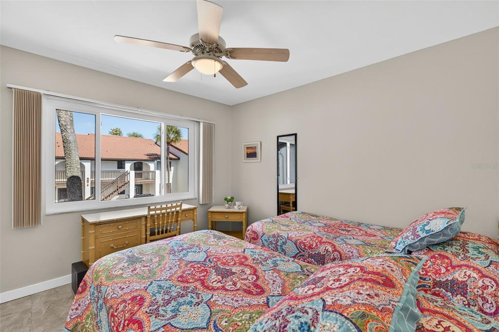 1632 Stickney Point Road, Unit 201 Sarasota, FL 34231 - Photo 19 of 43 a bedroom with a large bed and a chandelier
