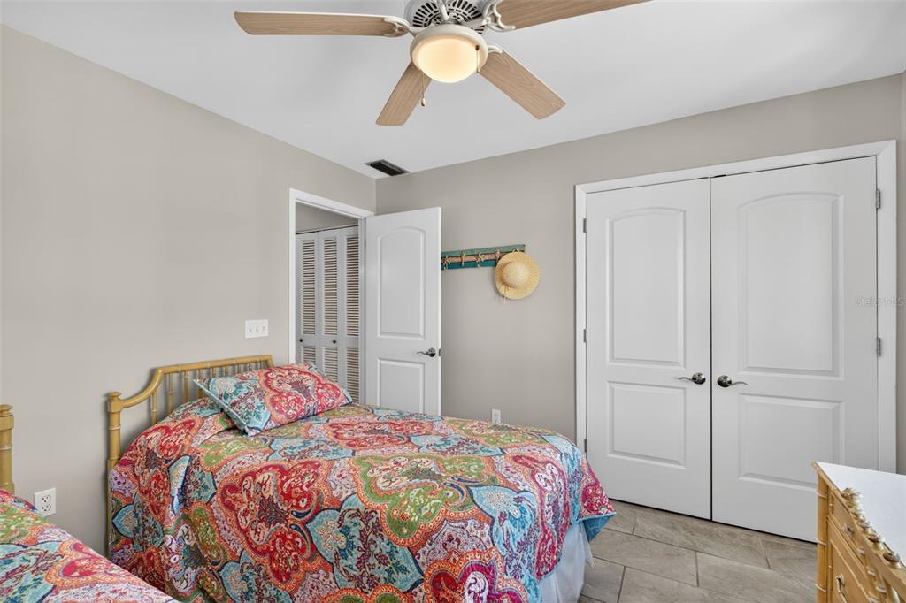 1632 Stickney Point Road, Unit 201 Sarasota, FL 34231 - Photo 20 of 43 a bedroom with a bed and a chandelier