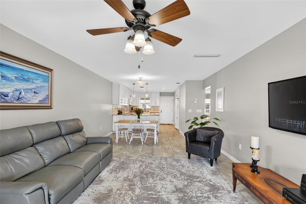 1632 Stickney Point Road, Unit 201 Sarasota, FL 34231 - Photo 2 of 43 a living room with furniture a chandelier and a flat screen tv