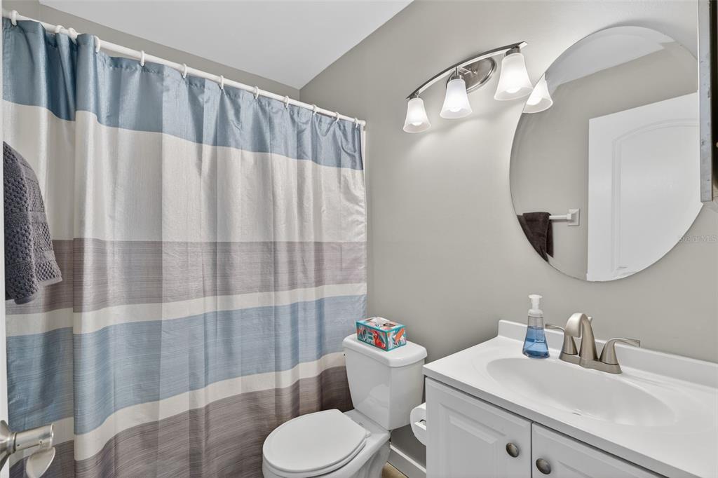 1632 Stickney Point Road, Unit 201 Sarasota, FL 34231 - Photo 21 of 43 a bathroom with a sink a toilet and shower curtain