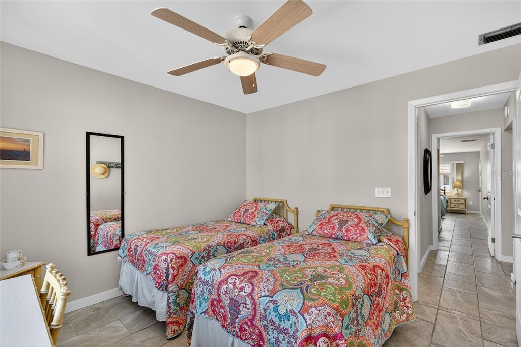 1632 Stickney Point Road, Unit 201 Sarasota, FL 34231 - Photo 22 of 43 a bedroom with a bed and a chandelier