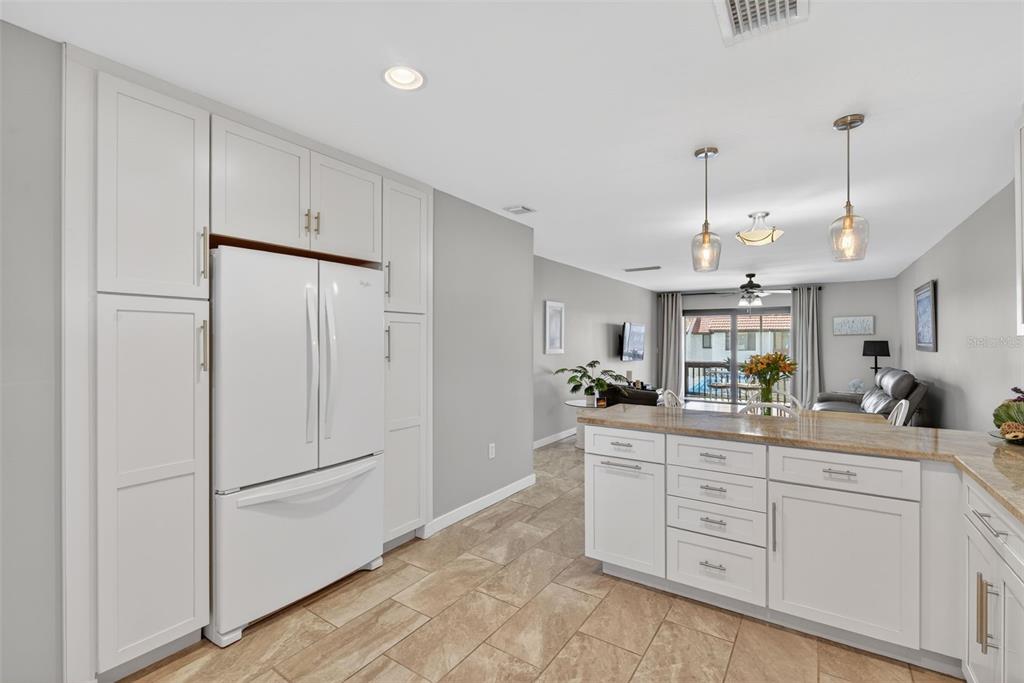 1632 Stickney Point Road, Unit 201 Sarasota, FL 34231 - Photo 10 of 43 a kitchen with white cabinets and center island