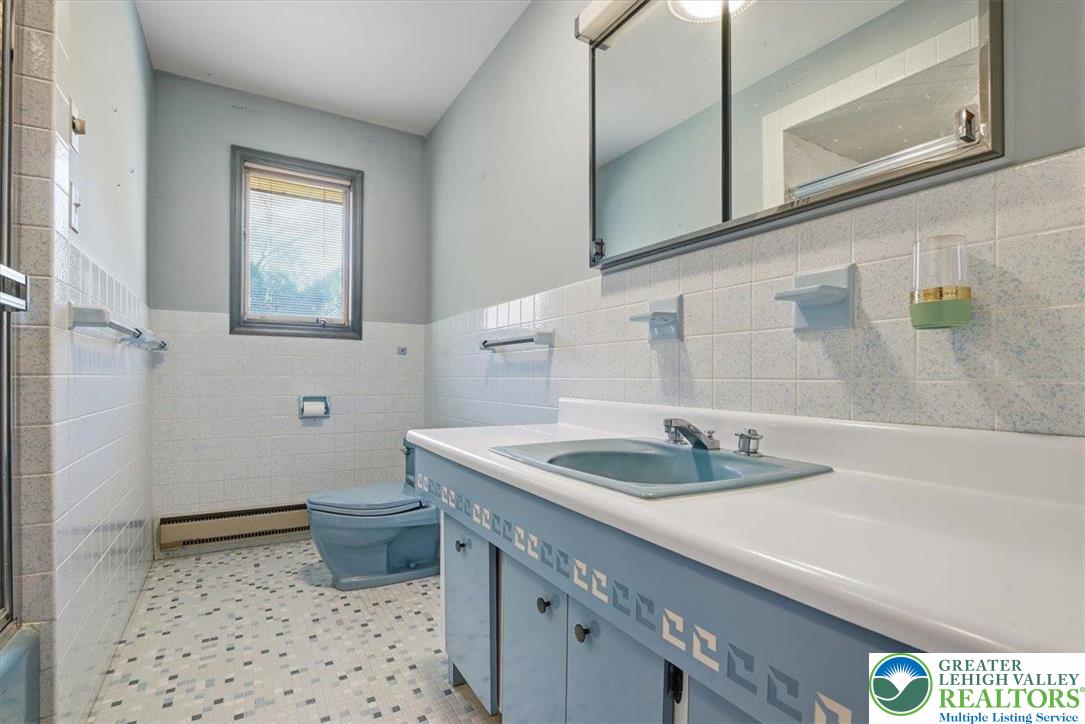 4395 East Texas Road Allentown, PA 18103 - Photo 45 of 81 a bathroom with a granite countertop sink a toilet and mirror