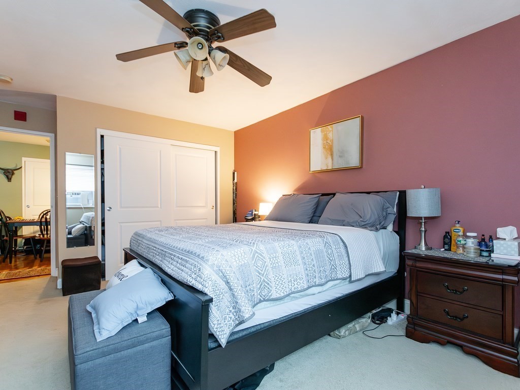 48 Coffey Street, Unit 5B Boston, MA 02122 - Photo 16 of 31 a bedroom with a bed and a chandelier