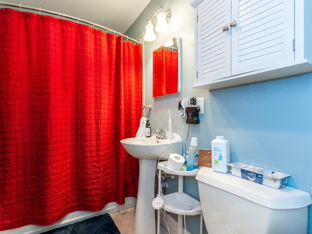 48 Coffey Street, Unit 5B Boston, MA 02122 - Photo 18 of 31 a bathroom with a sink a toilet and curtain