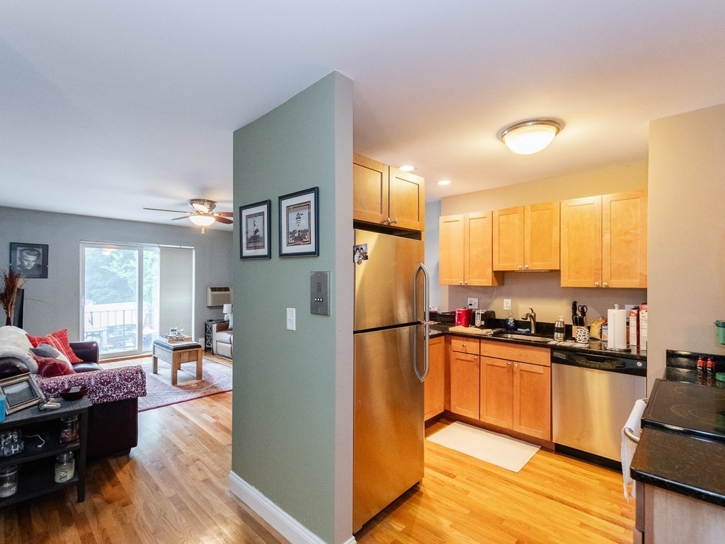 48 Coffey Street, Unit 5B Boston, MA 02122 - Photo 8 of 31 a kitchen with a refrigerator a stove top oven a sink dishwasher and wooden cabinets